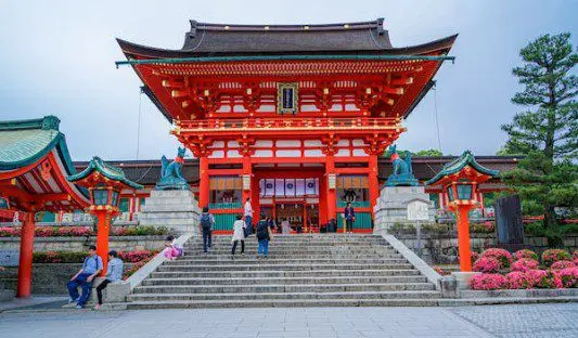 A red building with people walking up the steps.