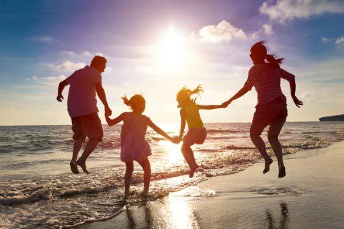 A family jumping in the air on the beach