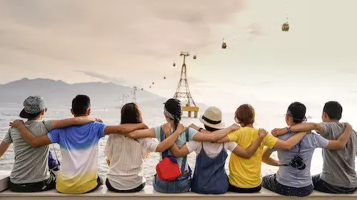 A group of people sitting on the beach