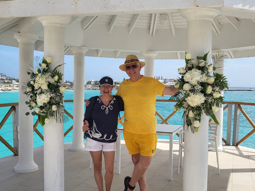 A man and woman standing under an arch.