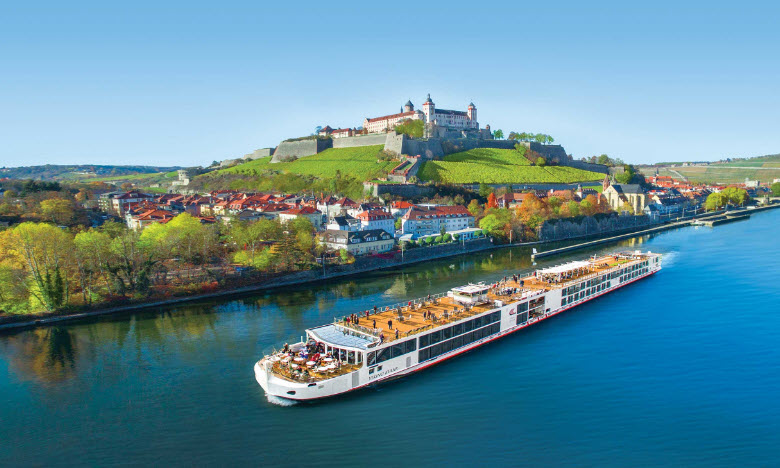 A large boat on the water near some buildings.