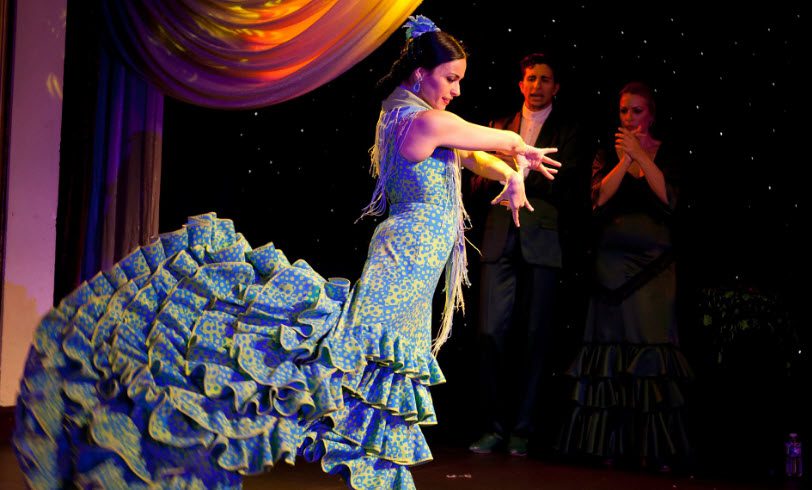 A woman in blue dress performing on stage.