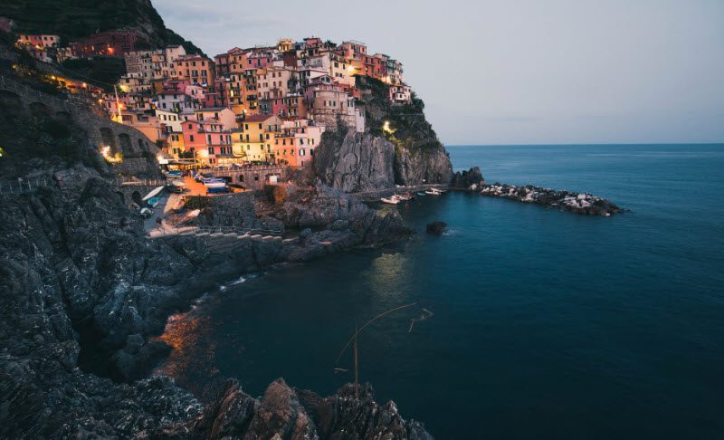 A view of the ocean and houses on top of a cliff.