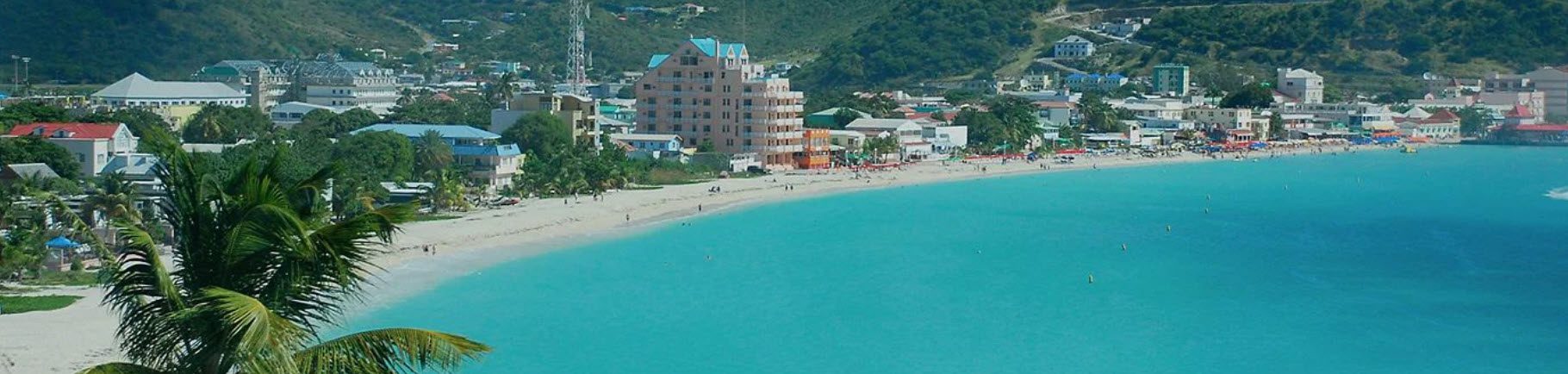 A beach with people swimming in the water.