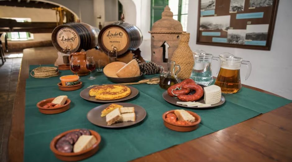 A table with plates of food and wine on it.