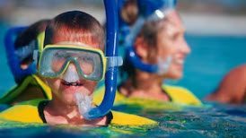 A man and woman wearing goggles in the water.