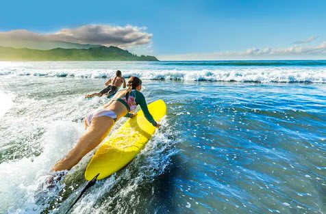 A woman riding on top of a surfboard in the ocean.