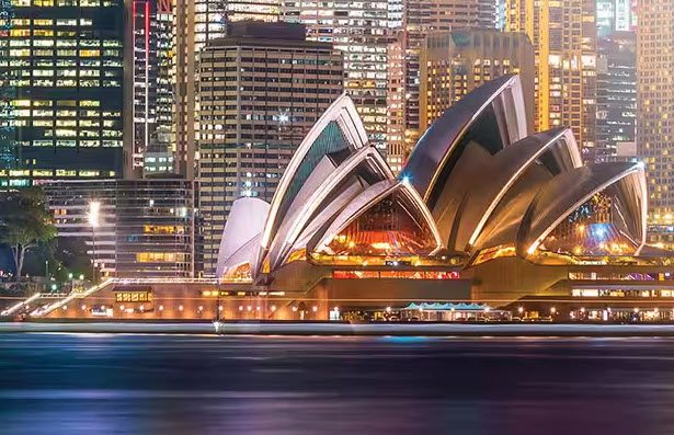 A view of the sydney opera house from across the water.