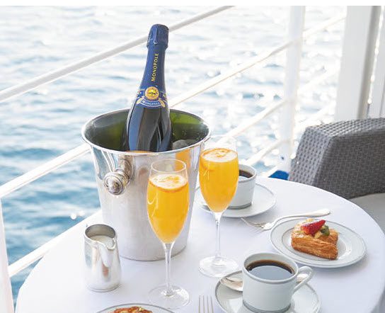 A bottle of champagne and two glasses on a table.