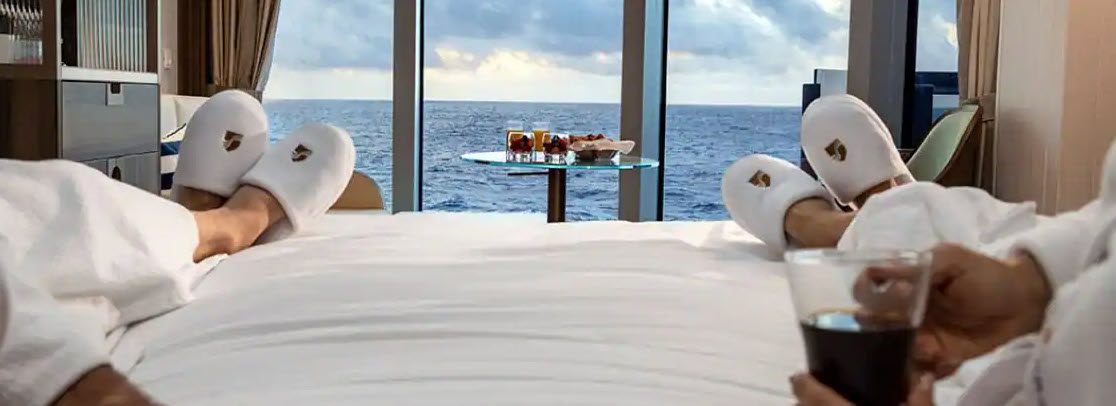 A table with drinks on it and the ocean in the background.